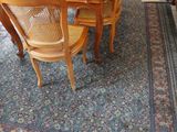 une table et des chaises dans une pièce avec un tapis au sol