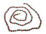 a close up of a necklace and bracelet with red and green beads