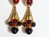 two pairs of earrings with red and black stones on them