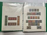 an open book with stamps on it sitting on top of a table
