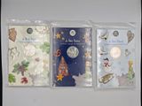 three christmas cards are lined up in plastic bags on a table