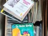a lot of records in a box on the floor