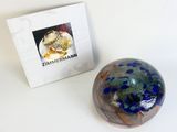 a glass ball sitting next to a box with a picture on it