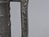 an antique silver coffee pot with an ornate design on the handle