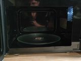 a man taking a picture of himself in the microwave