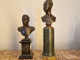 une paire de bustes en bronze représentant une femme et un homme, posés sur des socles en marbre