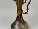a gold and blue vase with flowers on it