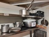 de nombreuses casseroles et poêles sur l'étagère de la cuisine