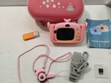 a pink case with a camera and other items on the table