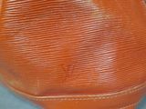 a close up of a brown purse on a table