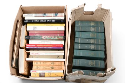 de nombreux livres dans une boîte en carton posée sur une surface blanche