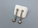 a pair of diamond earrings on a white cloth