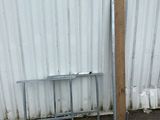 une table en métal et un banc en métal devant un mur blanc