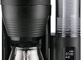 la cafetière se trouve à côté d'un verre sur un fond blanc