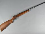 a rifle that is laying on a white surface