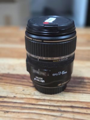 the camera lens is sitting on a wooden table with a blurry background