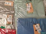 several shirts are wrapped in plastic and sitting on top of each other