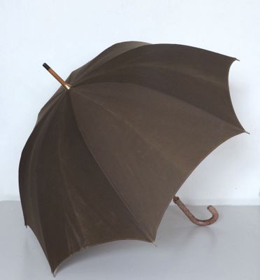 a brown umbrella with a wooden handle on a white surface