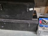 two black boxes and a blue bin in a garage