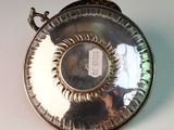 a silver plate with a picture on it on a table