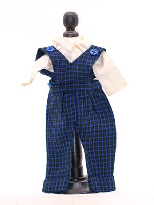 une salopette à carreaux bleus et noirs, avec une chemise blanche et un nœud papillon