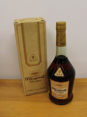 the bottle of brandy is next to the box on the table