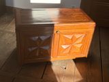 a wooden cabinet sitting on a wooden floor next to a window