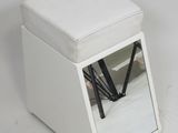 a small white ottoman with a mirror on top of it
