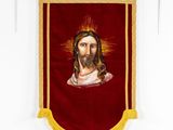 a red banner with a picture of jesus on it hanging on a wall