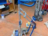 a blue hand truck with a blue handle in a garage