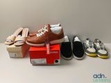 plusieurs paires de chaussures posées sur une boîte, à côté d'une paire de chaussures