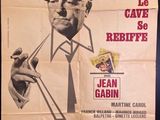 poster of a man in a hat and tie smoking a cigarette
