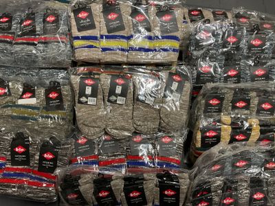 many bags of clothing wrapped in plastic on top of each other