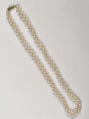 a close up of a necklace on a table with a white background