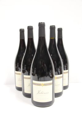 six bottles of red wine are lined up on a white surface