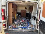 a white van with a lot of junk in the back