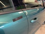a blue car with a sticker on the side of it