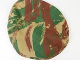 a brown and green camouflage hat on a white surface