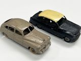 deux voitures jouets assises l'une à côté de l'autre sur une surface blanche