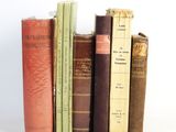 plusieurs vieux livres sont empilés sur une surface blanche