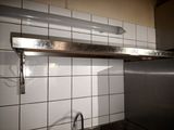 a metal shelf above a sink in a kitchen