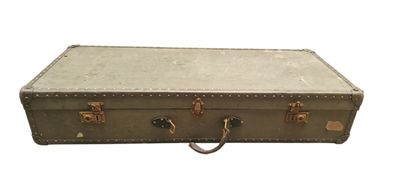 une vieille valise posée sur une surface blanche