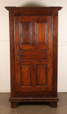 an old wooden cabinet with a door on top of it in a room