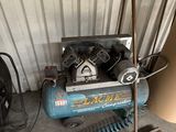 a blue air compressor sitting next to a pile of tools