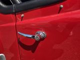 un gros plan d'une voiture rouge avec une poignée de porte chromée