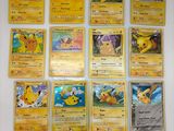 les cartes pokémon sont alignées sur une surface blanche