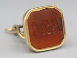 an image of a gold ring with a carnel stone in the center