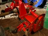 a red tractor that is sitting in the dirt