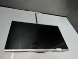 une télévision à écran plat posée sur une table blanche