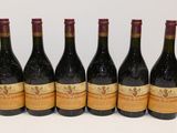 six bouteilles de vin sont alignées sur une table